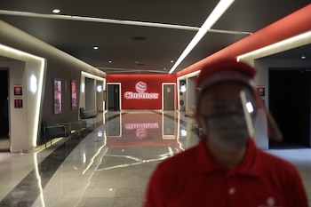 An employee wearing protective face masks stands guard inside in an area of movie theater "Cinemex" during the gradual reopening of commercial activities after the city government eased isolation measures implemented to prevent the spread of the coronavirus disease (COVID-19) in Mexico City, Mexico August 12, 2020. REUTERS/Henry Romero