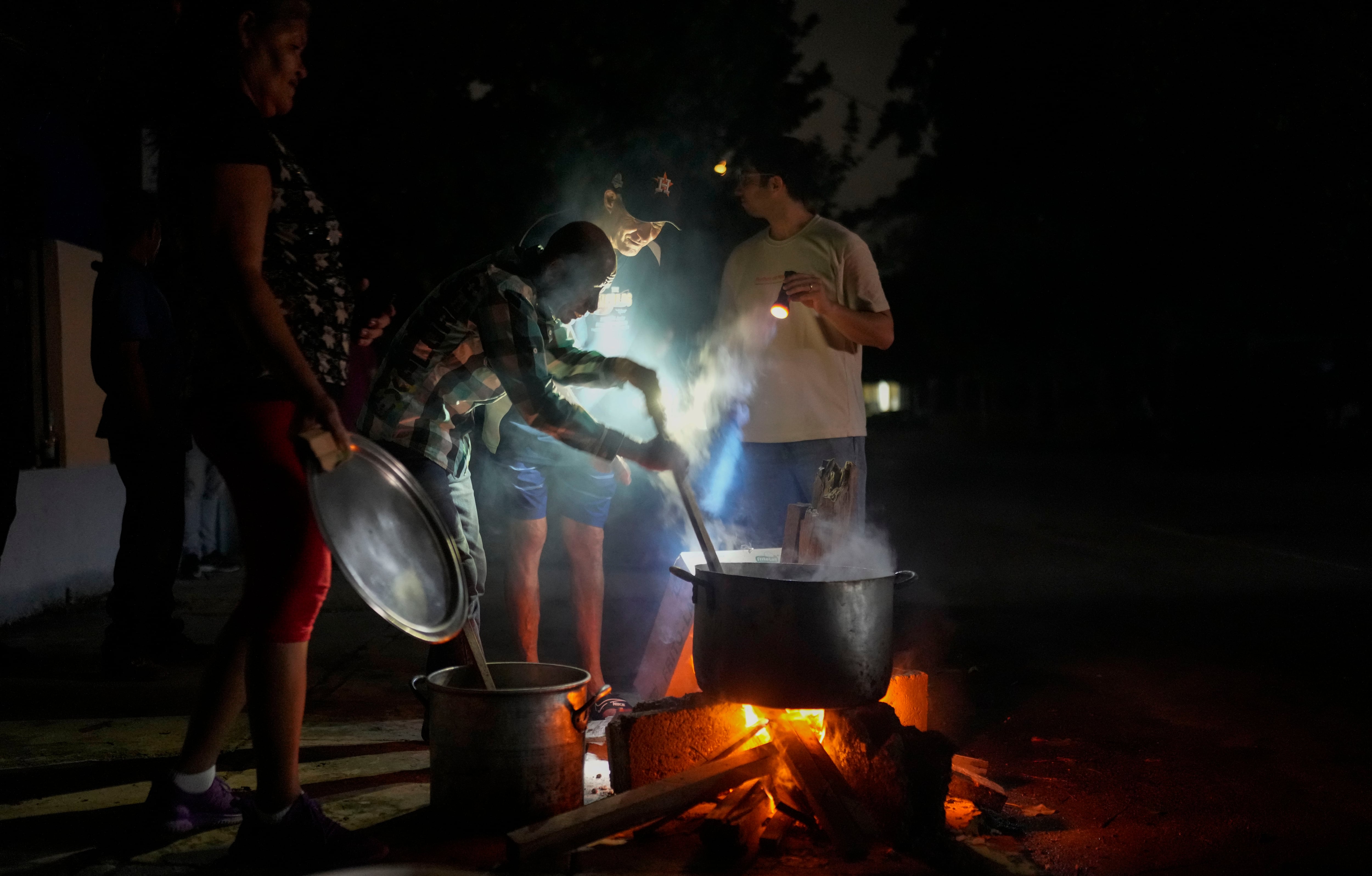 Residentes preparan sopa en un fuego de leña al aire libre durante un apagón tras un problema en una importante central eléctrica, en La Habana, Cuba, el 19 de octubre de 2024. (AP Foto/Ramón Espinosa)