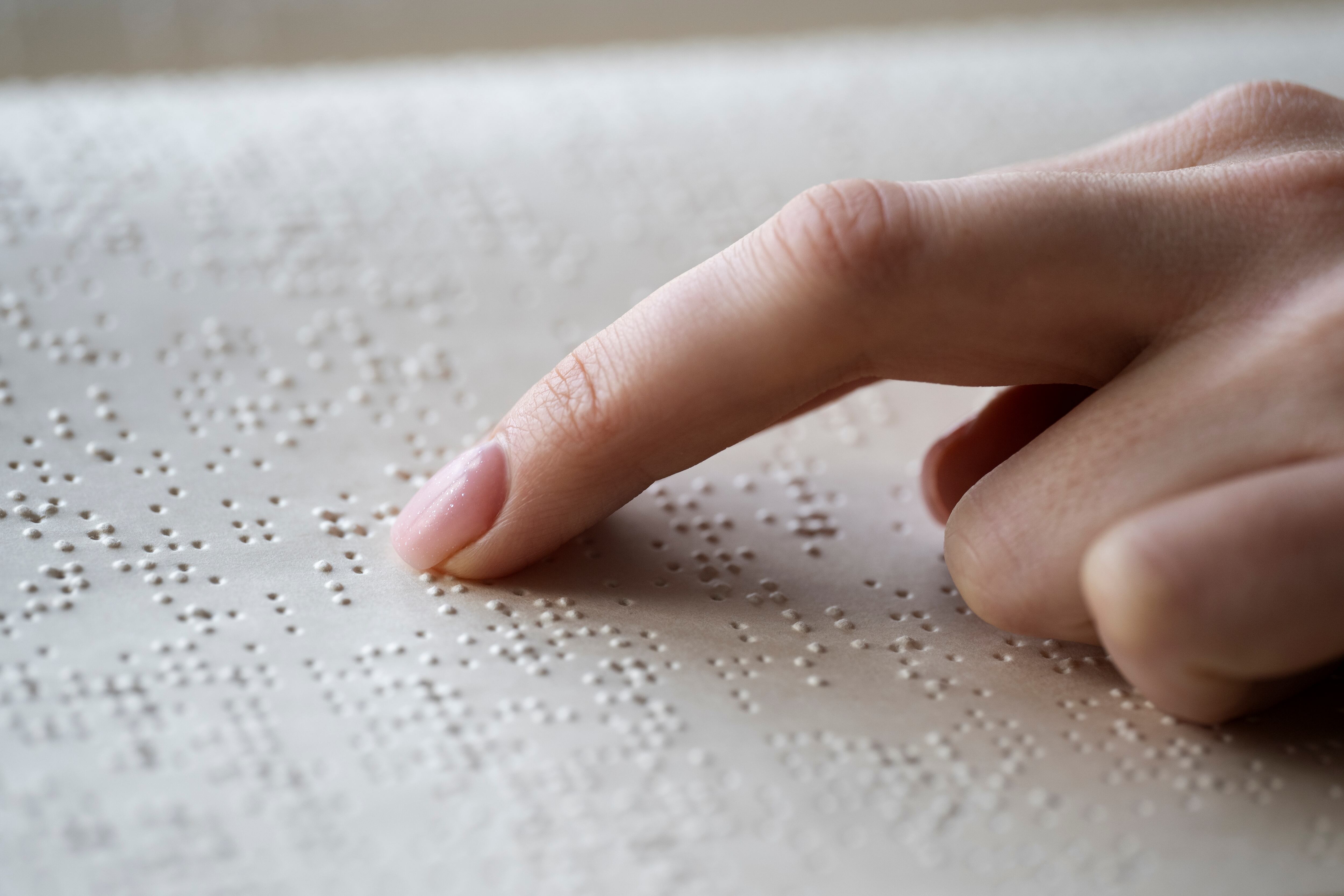 Una persona ciega leyendo en braille (Freepik)