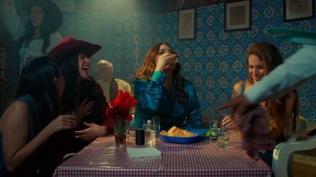 Un grupo de personas se reúne en una mesa de un restaurante, disfrutando de una celebración en un ambiente festivo. (Yuridia/Youtube)