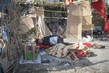 Varios inmigrantes acampados en la playa del Trampolín, a 19 de agosto, en Ceuta. (Marcos Moreno / Europa Press)