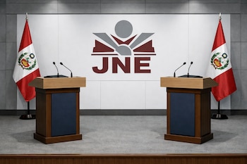 Escenario de debate presidencial vacío con dos podios, banderas de Perú a los lados y el logo grande del JNE en la pared blanca del fondo.