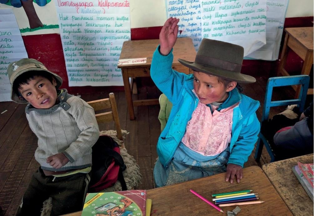 Niños participan activamente en su aula, reflejando la necesidad de políticas gubernamentales que aseguren su educación y bienestar integral en Perú. (UNICEF)