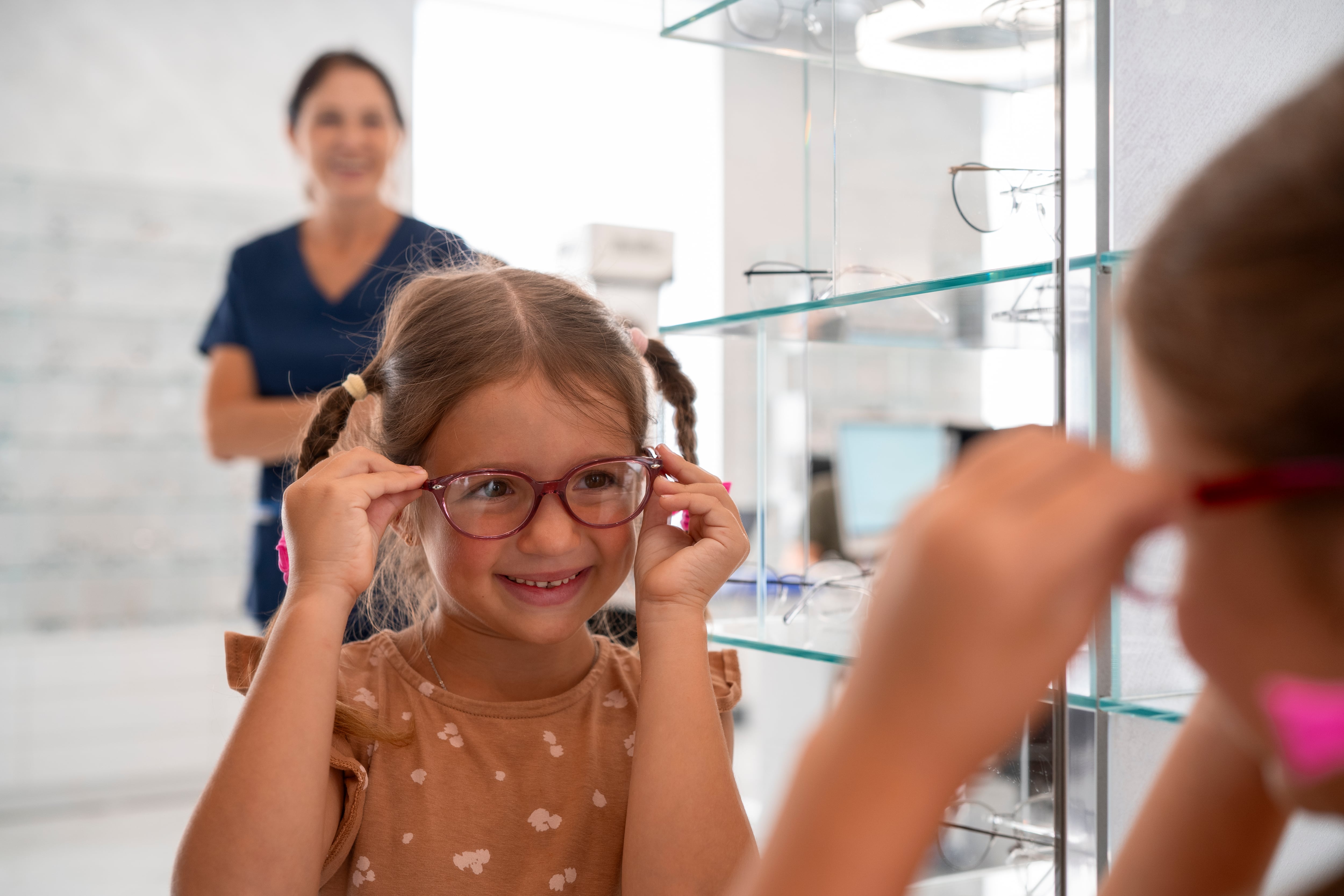 Una niña se prueba unas gafas en una óptica. (Freepik)