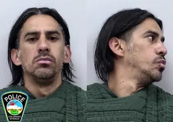 Ficha policial de un hombre con cabello oscuro y barba, mostrando vista frontal y de perfil. Viste una camisa verde acolchada. Incluye el logo de Policía de Colorado Springs