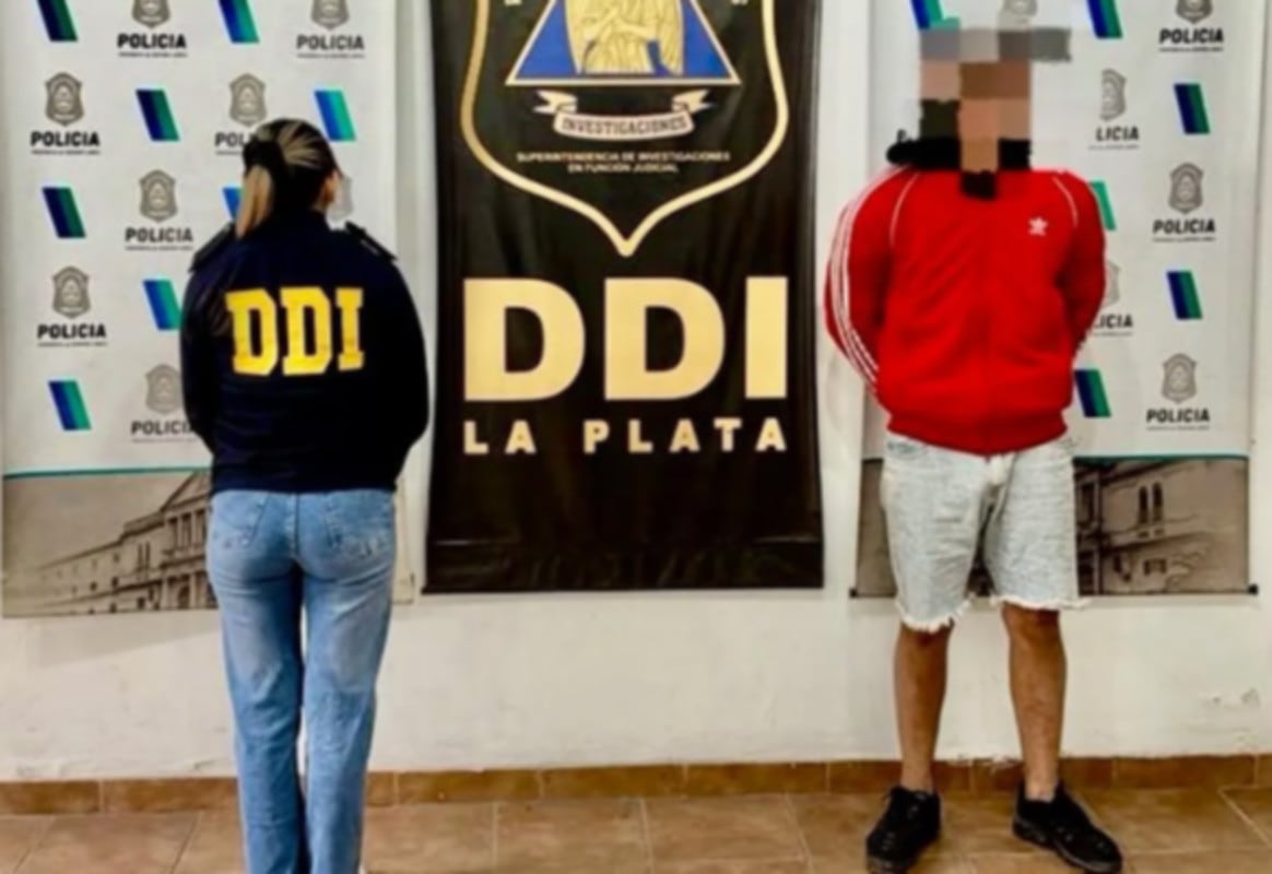 Una agente de la DDI La Plata escolta al joven detenido por el robo a un chofer de aplicación de viajes (0221)