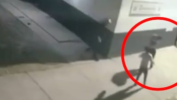 Imagen de videovigilancia borrosa mostrando dos figuras humanas en una pelea nocturna en una acera, con una de ellas resaltada en un círculo rojo