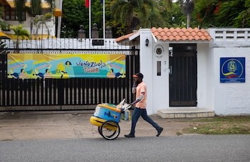 Fotografía de archivo en la que se captó a un vendedor de helados al pasar frente a la entrada principal de la embajada de Venezuela en Santo Domingo (República Dominicana). EFE/Orlando Barría