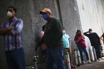 Personas hacen fila para llenar