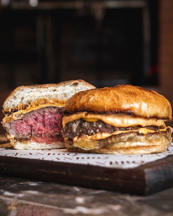 Clan Burger con fraldinha a la brasa, cheddar inglés y salsa de la casa en pan brioche tostado al carbón, con perfil ahumado