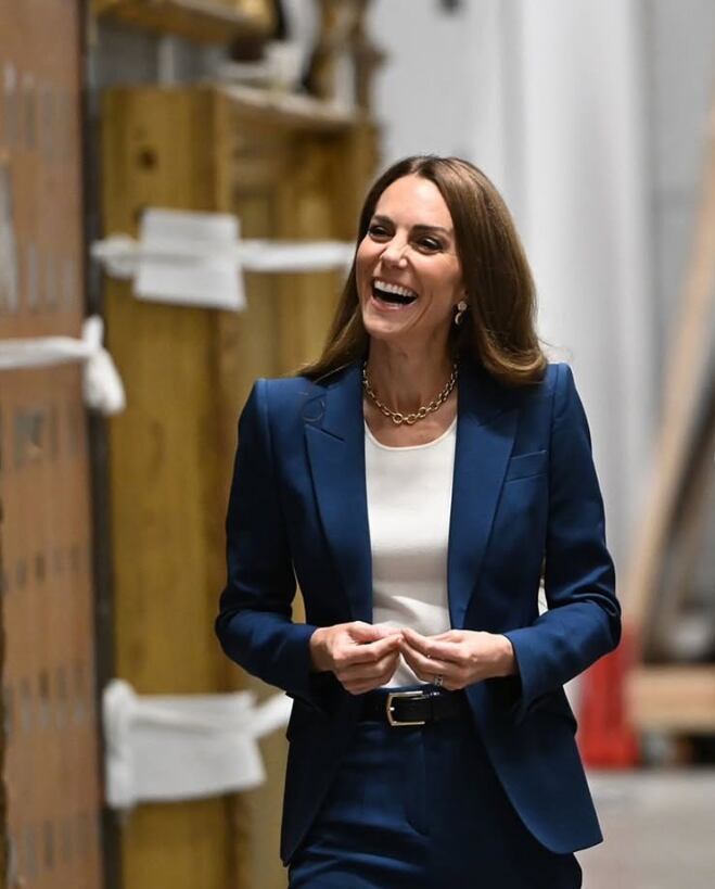El traje sastre azul con camiseta blanca y accesorios metálicos, ideal para entornos industriales, resalta la imagen profesional y versátil de Kate Middleton (katemiddletonprincessofwalesuk)