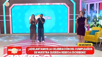 Um homem e duas mulheres na televisão com um microfone, em frente ao telão e o aniversário de Rebeca Escribns