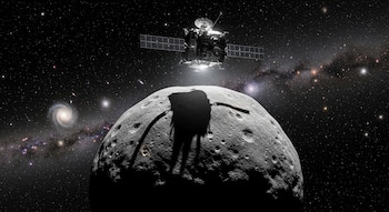 Nave espacial sobre un asteroide irregular con cráteres. Su sombra se proyecta en la superficie rocosa. Fondo con estrellas y galaxias.