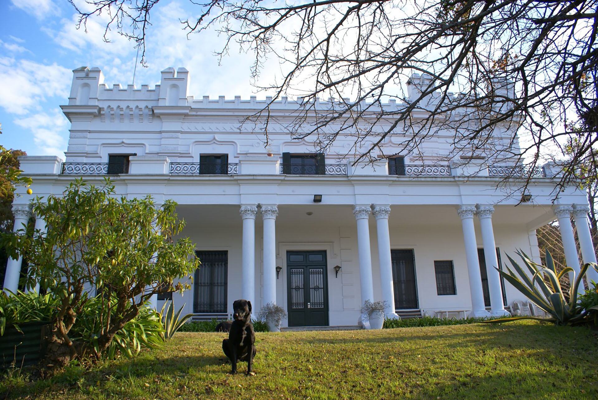 Vista de la fachada que mira hacia el río y uno de los perros que cuidan el lugar