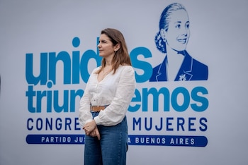 Una mujer habla ante un micrófono flanqueada por dos hombres y, debajo, varios dirigentes políticos posan en un escenario al aire libre