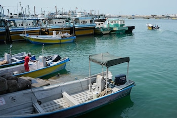 Un hombre trabaja a bordo de una embarcación mientras una lancha a motor sale de un puerto en Bandar Abbas, Irán, el domingo 6 de septiembre de 2026 (AP/Vahid Salemi)