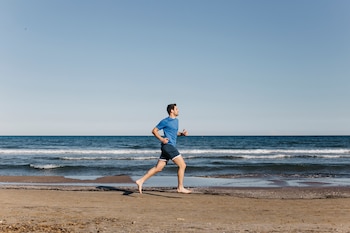 Un hombre corriendo por la playa (Magnific)