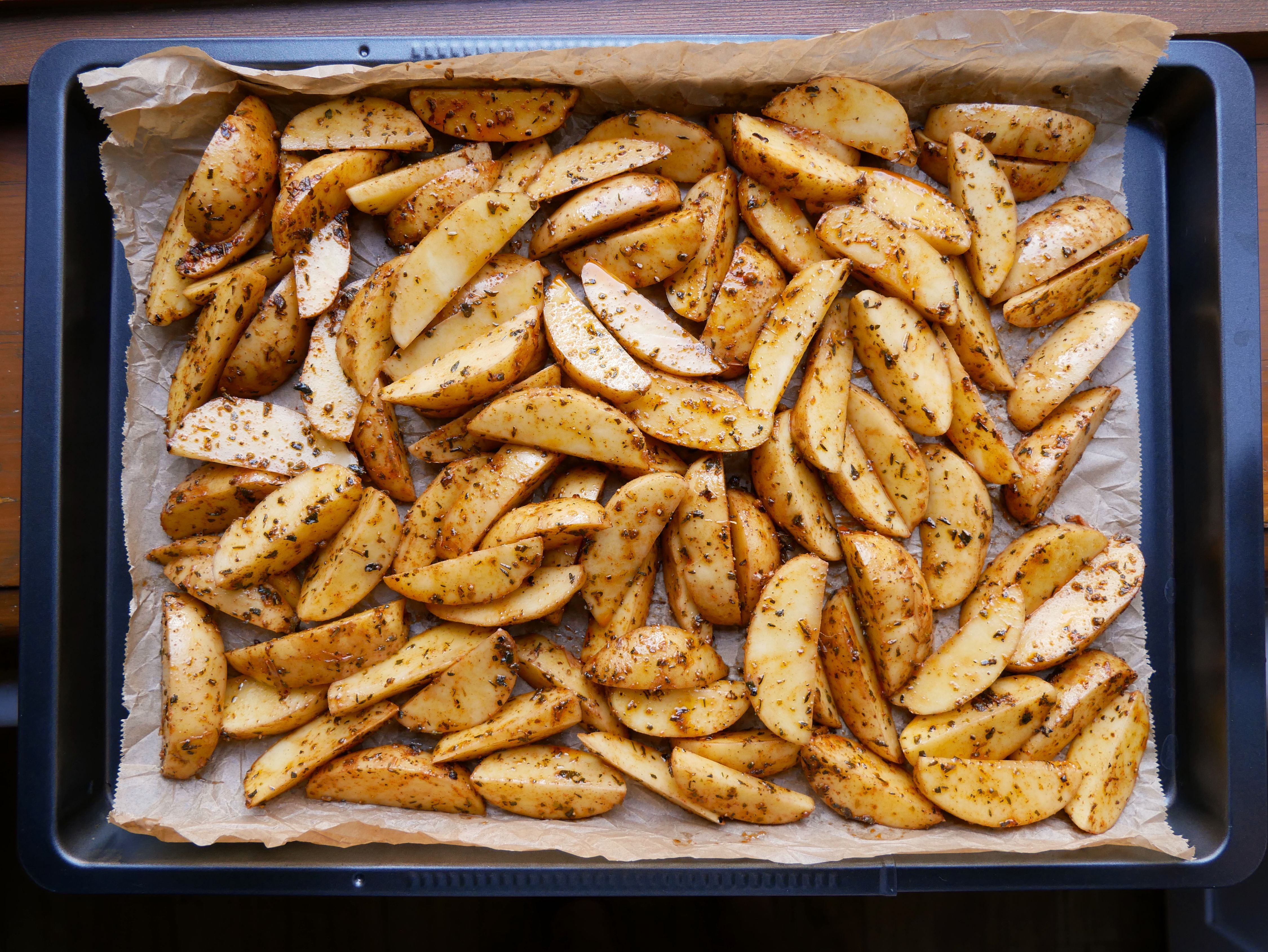 Las patatas cortadas en bastones se distribuyen en una sola capa sobre la bandeja antes de hornearlas a 220 grados, un paso clave para lograr una textura crujiente con menos aceite. (Pexels/Lena Netkach)