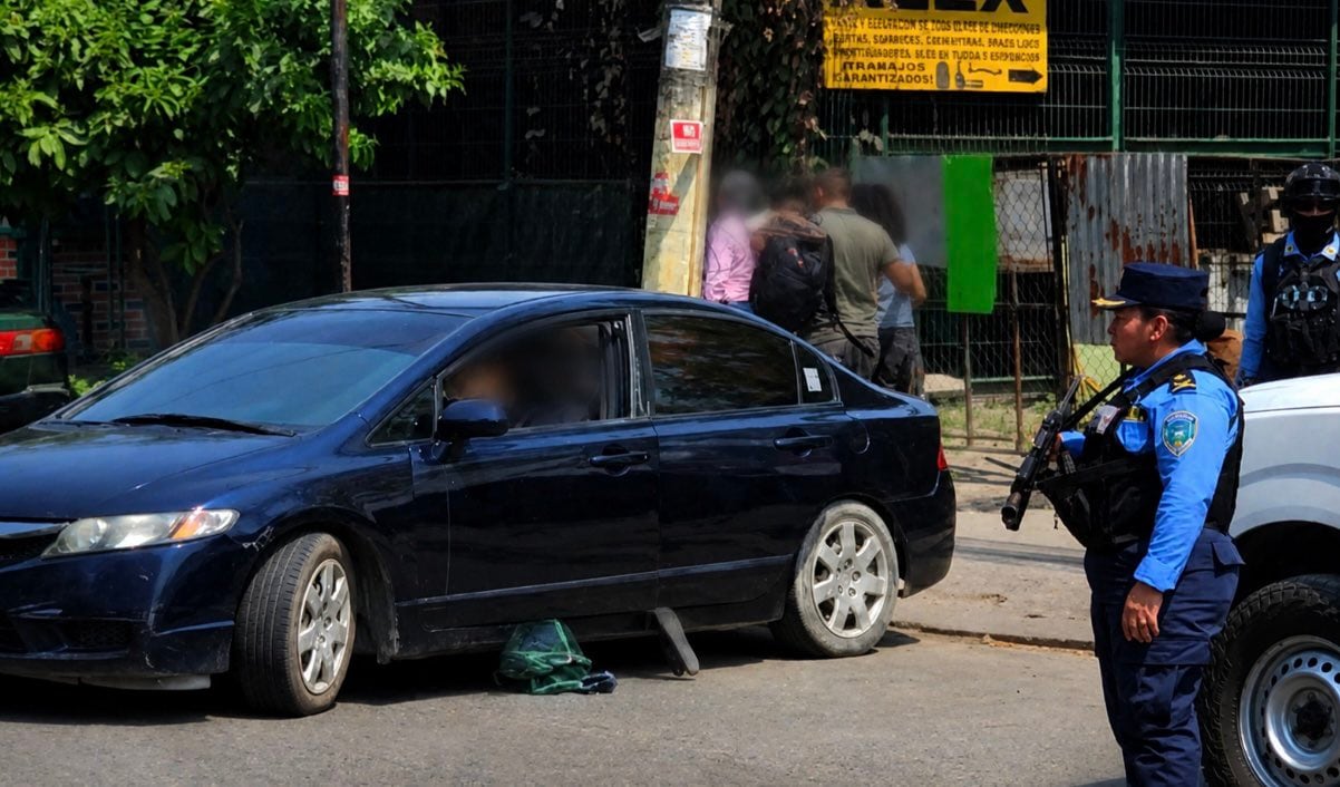 Escena del crimen donde madre e hijo fueron asesinados dentro de un vehículo en San Pedro Sula. (FOTO: X)