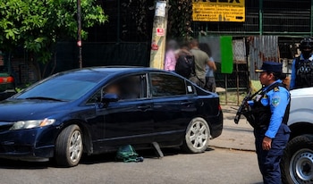Escena del crimen donde madre e hijo fueron asesinados dentro de un vehículo en San Pedro Sula. (FOTO: X)