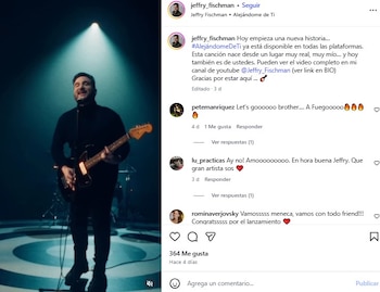 Jeffry Fischman en un escenario oscuro, tocando una guitarra eléctrica bajo un foco brillante, vistiendo una camisa de cuello alto negra y pantalones negros