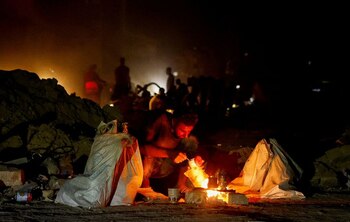 Un hombre en cuclillas junto a una fogata (REUTERS/Mohammed Salem)