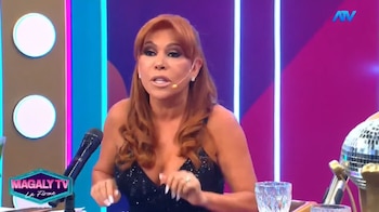Magaly Medina sentada frente a un micrófono en el set de su programa de televisión