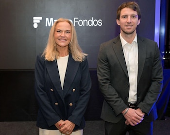 Pilar Gómez Bravo, mujer rubia con chaqueta azul, y Mateo Brito, hombre en traje oscuro, de pie frente a un logo blanco de Macro Fondos sobre fondo oscuro