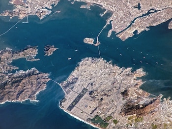 Vista aérea de la Bahía de San Francisco con ciudades, puentes, islas, barcos y montañas, extendiéndose desde la costa del Pacífico