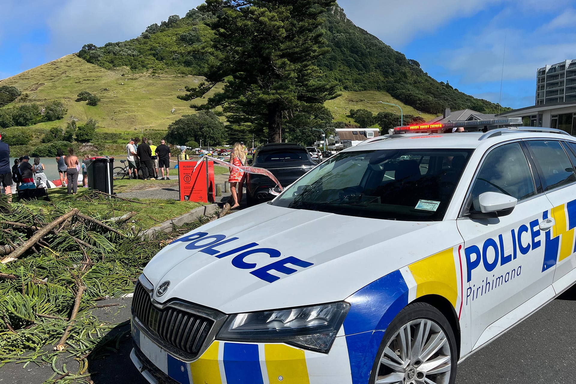 Equipos de emergencia y transeúntes inspeccionan la escena después de que un deslizamiento de tierra afectara un campamento en el monte Maunganui, Nueva Zelanda, el jueves 22 de enero de 2026. (Información vía AP)
