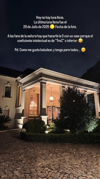 Mansión de estilo clásico iluminada de noche, con columnas en la entrada principal, un candelabro visible y sendero de adoquines