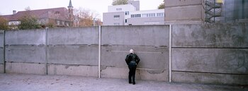 Un visitante mira a través de una brecha en los restos del Muro de Berlín en el sitio conmemorativo oficial del Muro de Berlín en Bernauer Strasse, en Berlín, Alemania, el lunes 28 de octubre de 2024.