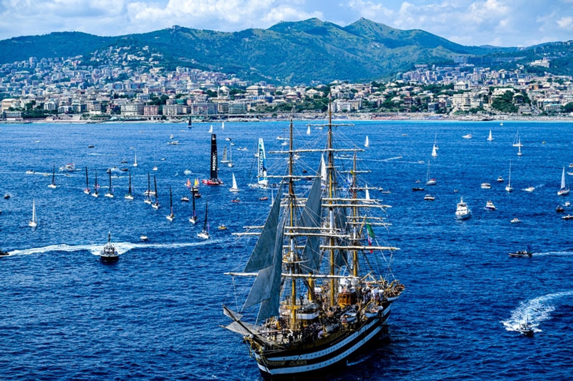 The Ocean Race VO65 Sprint Cup 2022-23 - 1 July 2023. Aerial view IMOCA In-Port Race in Genova. Army F35 planes fly over the Italian Navy Amerigo Vespucio tall ship.