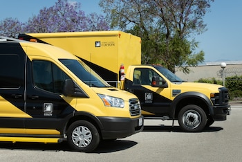 Una furgoneta y un camión de color amarillo y negro con el logotipo de Southern California Edison estacionados en el exterior