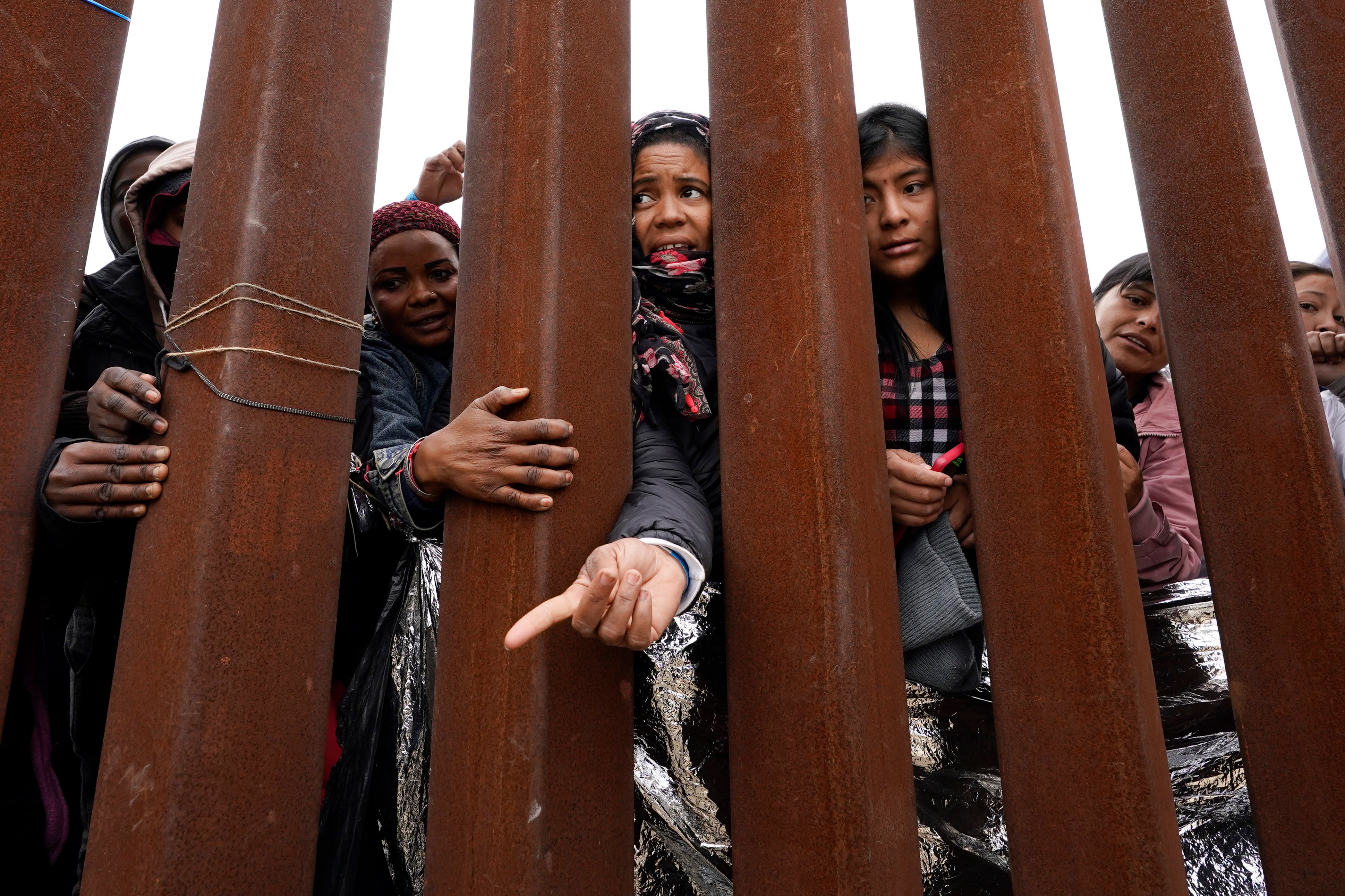 Cientos de migrantes aguardan entre dos muros fronterizos para solicitar asilo, en mayo de 2023, en San Diego (AP Foto/Gregory Bull)