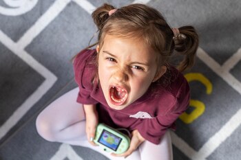 Una niña enfadada mientras juega con una máquina (Freepik)