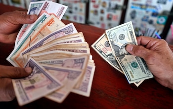 Personas muestran billetes de pesos