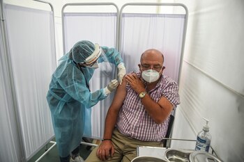 A health worker inoculates a