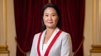 Retrato de Keiko Fujimori con cabello negro y saco blanco, lleva una banda presidencial roja y blanca con el escudo peruano, sobre un fondo de cortina roja.