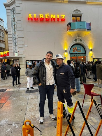 El productor Ramiro Navarro posa junto a uno de los empleados de la central eléctrica española cuando se cortó la luz y encontraron una solución para poder iluminar la sala donde se proyectó la película La casaca de Dios, en el festival de Málaga