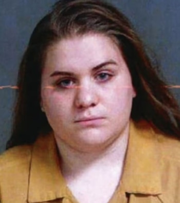 Foto policial de Savanah Collier, una mujer caucásica con cabello castaño oscuro, ojos claros y expresión seria, vistiendo un uniforme amarillo mostaza