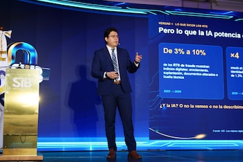 Un hombre con traje habla en un podio junto a la bandera de Guatemala y un panel conmemorativo del 80 aniversario de la Superintendencia de Bancos