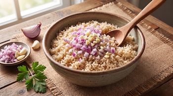 Tazón de arroz con cebolla morada picada y ajo. Cuchara de madera. Plato pequeño con cebolla y ajo. Gajo de cebolla y diente de ajo. Perejil.