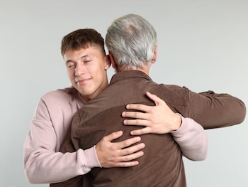 Un padre abraza a su hijo.