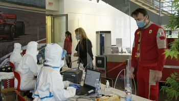 Los trabajadores con equipo de protección completo hablan con los empleados de Ferrari que regresan a trabajar tras la reapertura de la planta del fabricante de automóviles de lujo en Maranello (Ferrari SpA via Reuters)