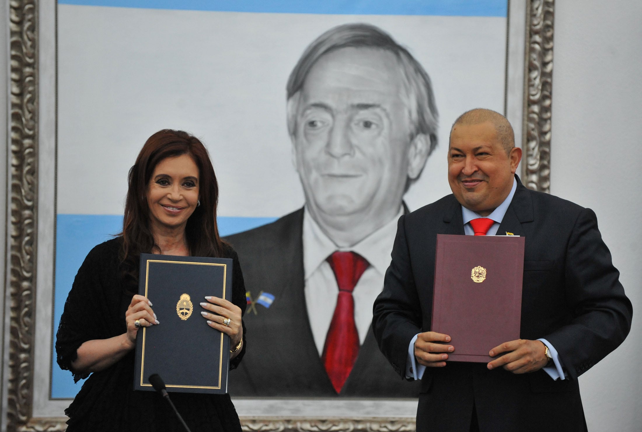 La entonces presidenta Cristina Kirchner y su par venezolano Hugo Chávez mostraban los libros con los convenios firmados. Detrás se observa el cuadro de Néstor Kirchner