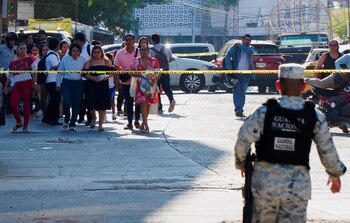 People stand behind a police