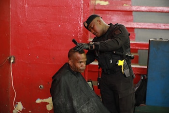 Persona en situación de calle recibe un corte de cabello por parte de un miembro de la guardia municipal. (Cortesía)