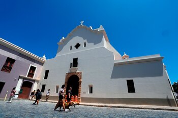 Grupos de personas caminan frente a la Iglesia de San José hoy, en San Juan (Puerto Rico). EFE/ Thais Llorca