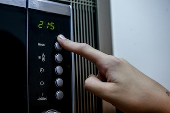 Una mujer calentando su comida